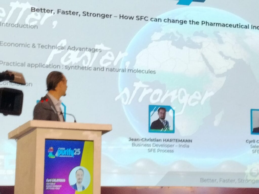 Speaker at the podium with a slide titled 'Better, Faster, Stronger: How SFC can change the Pharmaceutical Industry'